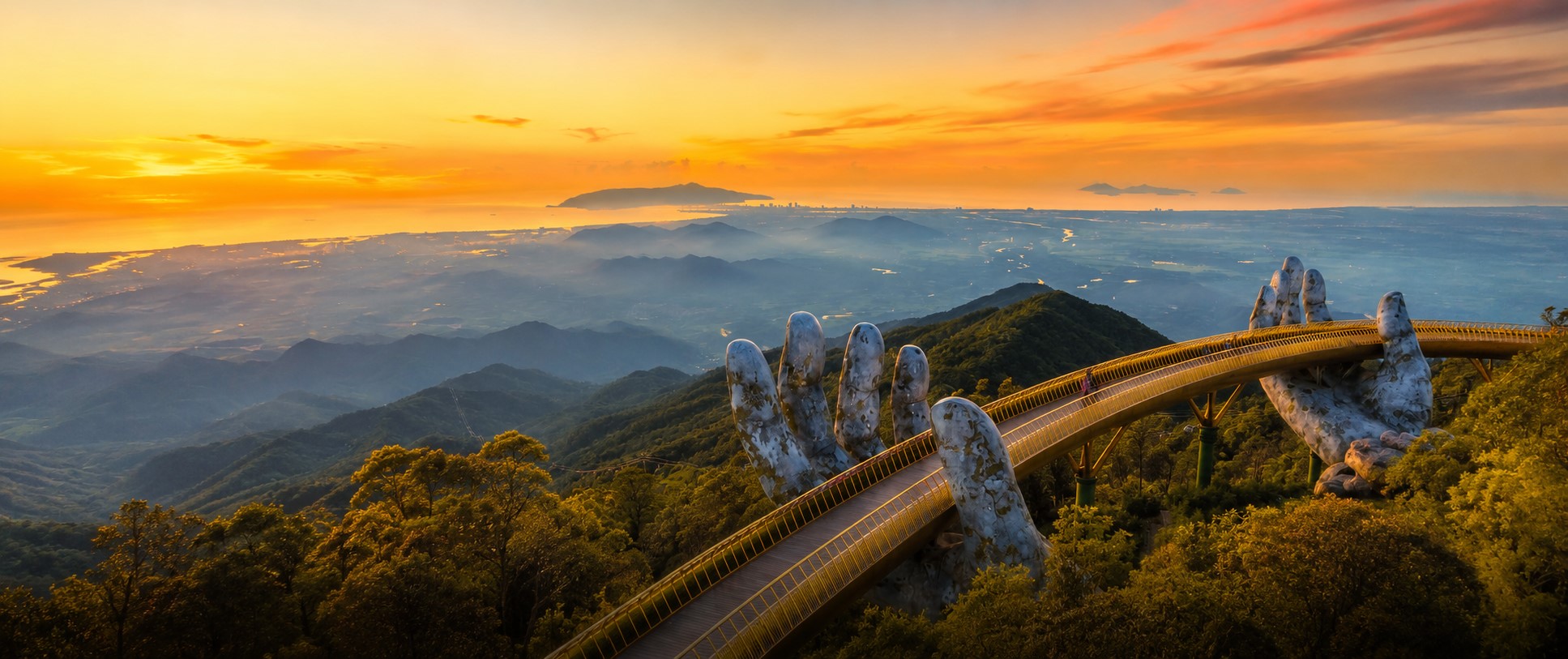 Golden Bridge Da Nang supported by giant stone hands at sunset