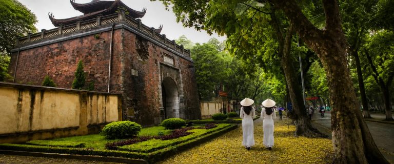 Cua Bac Gate in Hanoi with women in white ao dai.