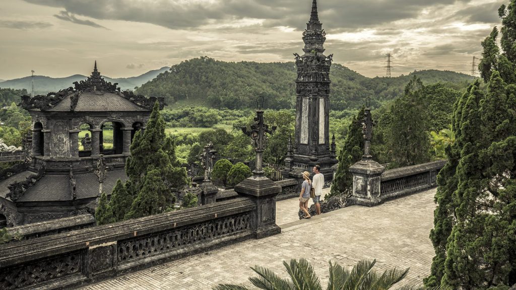 Panoramic view of Khai Dinh Tomb in Hue, with ornate stone architecture and surrounding green hills