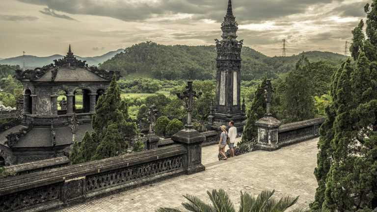 Panoramic view of Khai Dinh Tomb in Hue, with ornate stone architecture and surrounding green hills